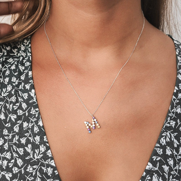 Woman wearing a colorful initial necklace made of sterling silver