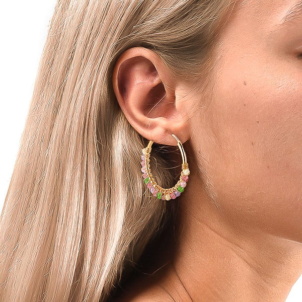 Woman wearing colorful bead hoop earrings