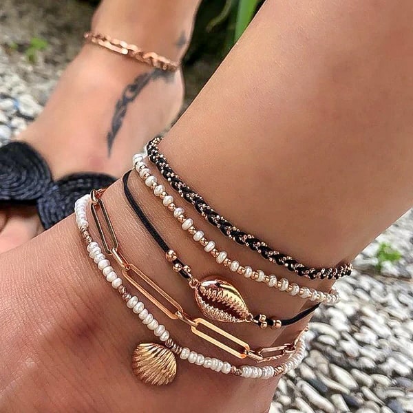 Cowrie and seashell anklet set on a womans ankle