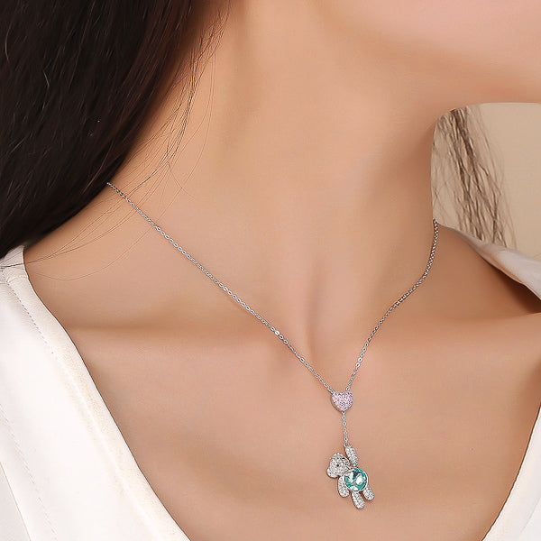 Crystal heart & teddy bear necklace on woman's neck