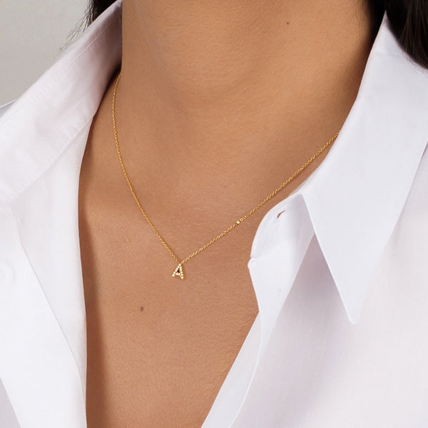 Woman wearing a dainty gold initial letter necklace