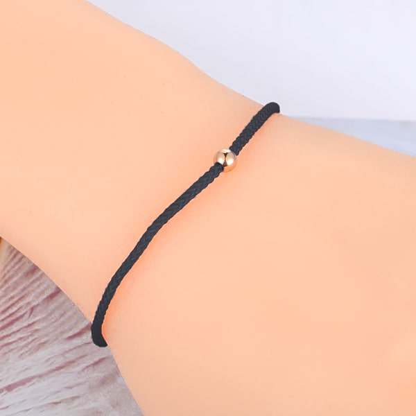 Dainty black rope bracelet on a woman's wrist