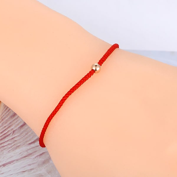 Dainty red rope bracelet on a woman's wrist