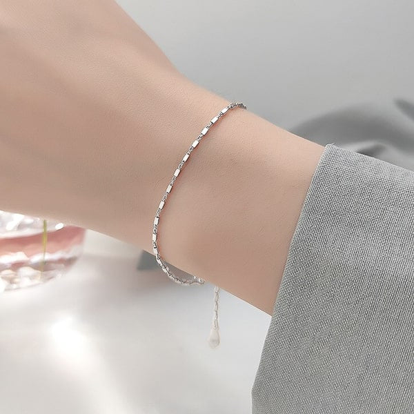 Dainty sterling silver chain bracelet on woman's wrist