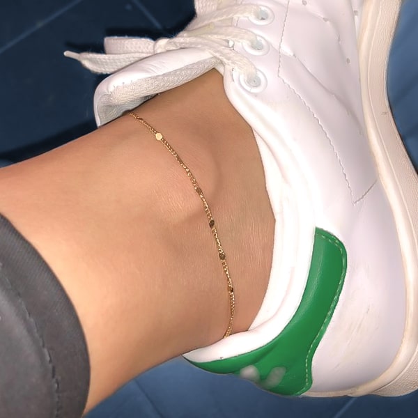 Delicate gold chain anklet on a womans ankle