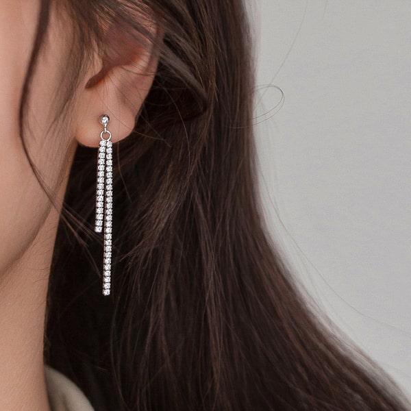Woman wearing double crystal drop chain earrings