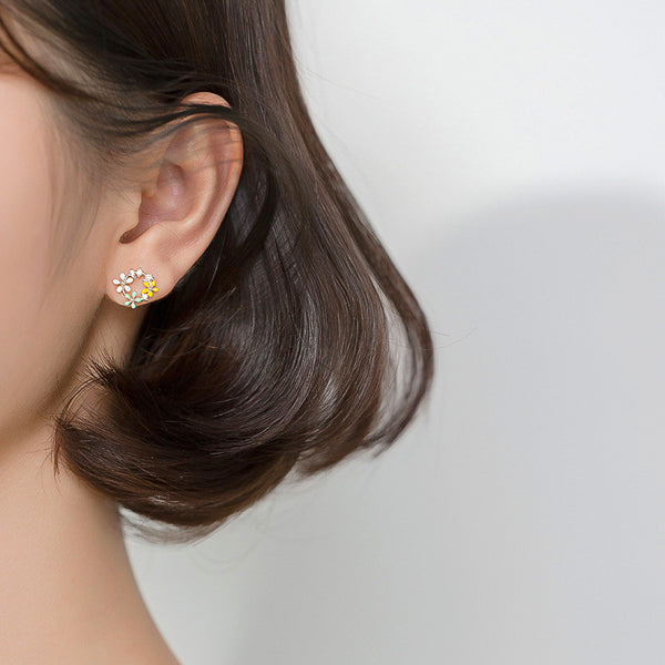 Woman wearing silver flower circle stud earrings