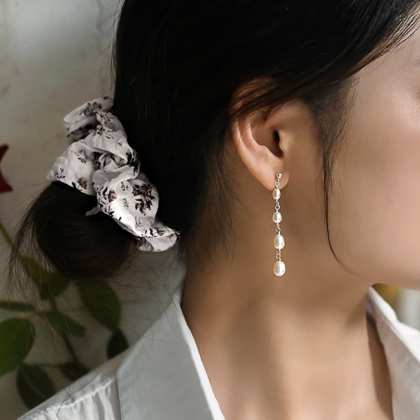 Woman wearing four pearl drop earrings