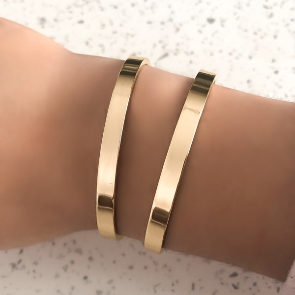 Woman wearing a 6mm gold bangle bracelet on her wrist