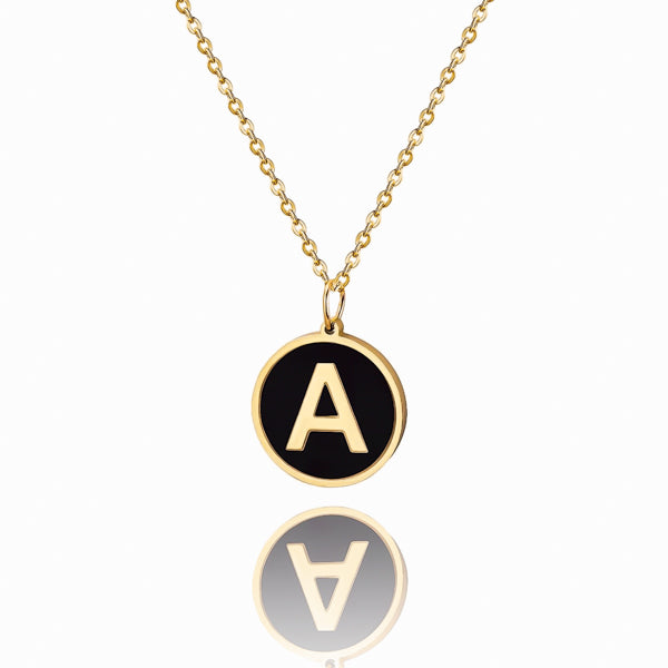 Gold and black round letter coin pendant necklace closeup