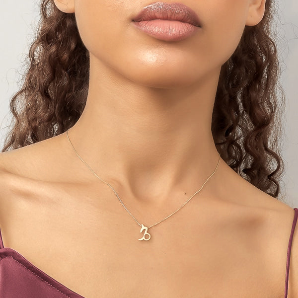 Woman wearing a gold Capricorn necklace