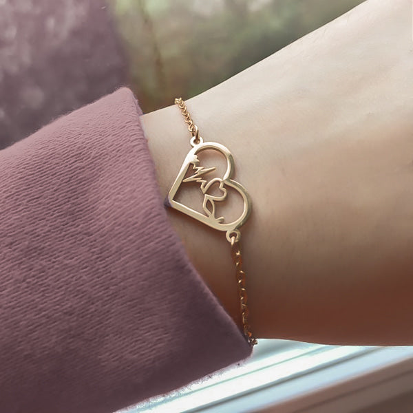 Woman wearing a gold heartbeat bracelet on her wrist
