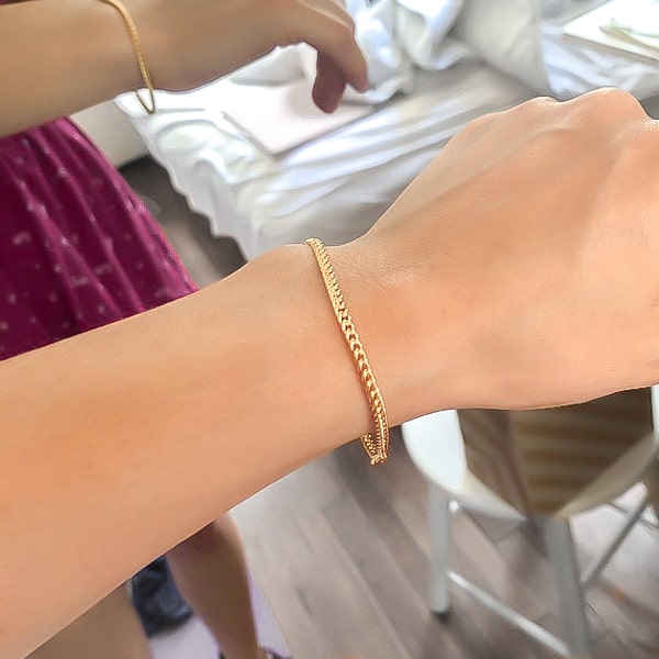 Gold Cuban link chain bracelet on a woman's wrist