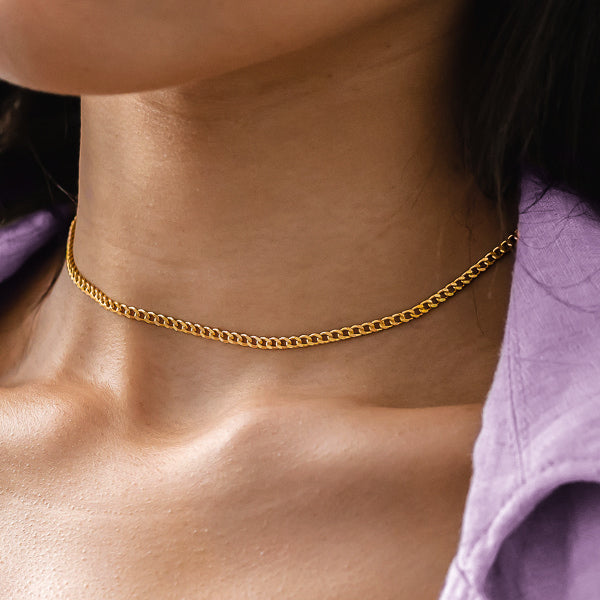 Woman wearing a gold curb chain choker necklace