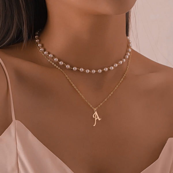 Woman wearing a gold cursive initial necklace