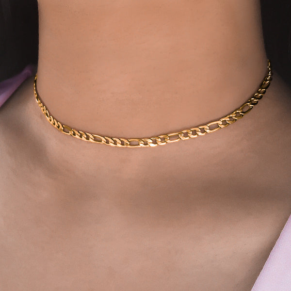 Woman wearing a gold figaro choker necklace