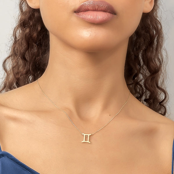 Woman wearing gold Gemini necklace