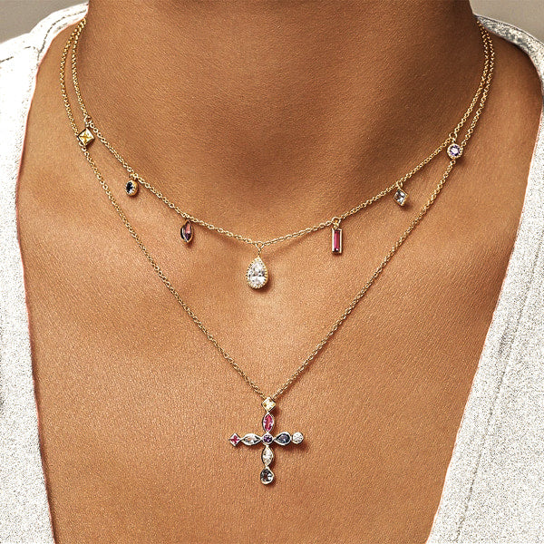 Woman wearing a gold Greek crystal cross necklace