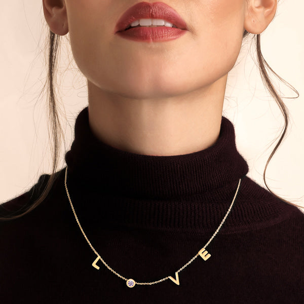 Woman wearing a gold LOVE necklace
