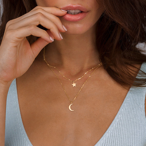 Gold layered star and moon necklace on woman