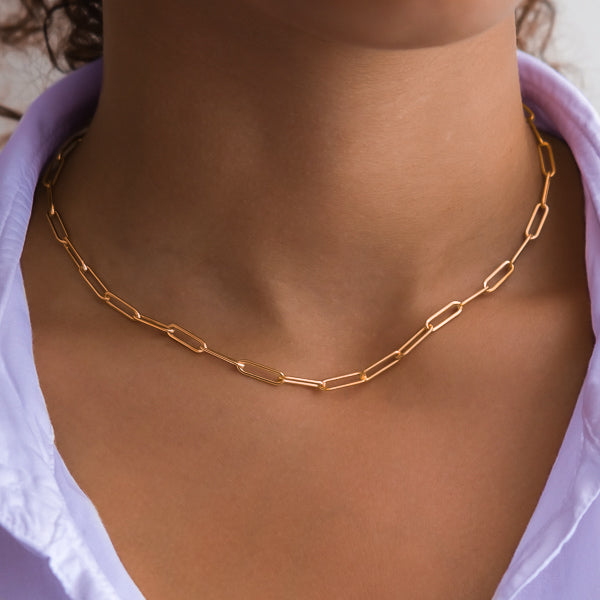 Woman wearing a gold paperclip chain necklace