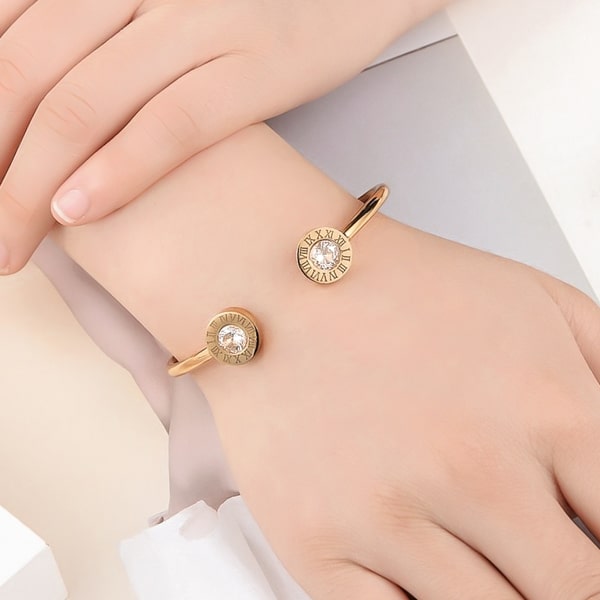 Woman wearing a gold Roman numeral cuff bracelet
