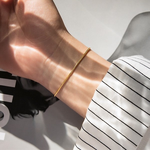 Gold snake chain bracelet on a woman's wrist