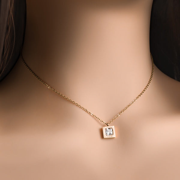 Woman wearing a gold square love crystal necklace
