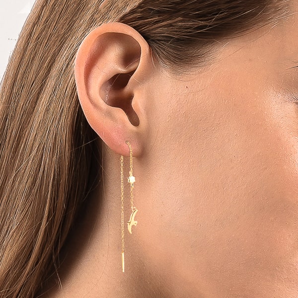 Woman wearing gold bird threader earrings