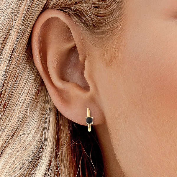 Woman wearing gold black solitaire hoop earrings