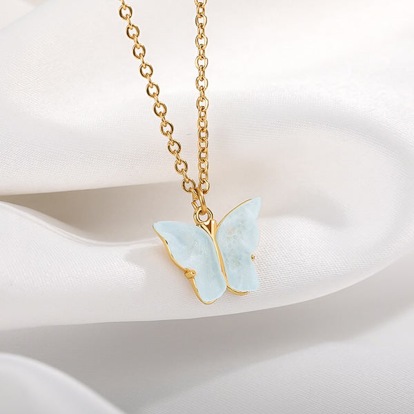 Blue butterfly pendant on a gold necklace display
