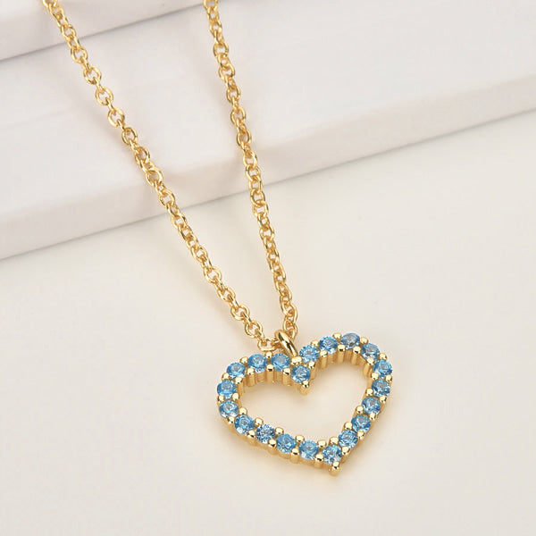 Blue crystal open heart on a gold necklace display