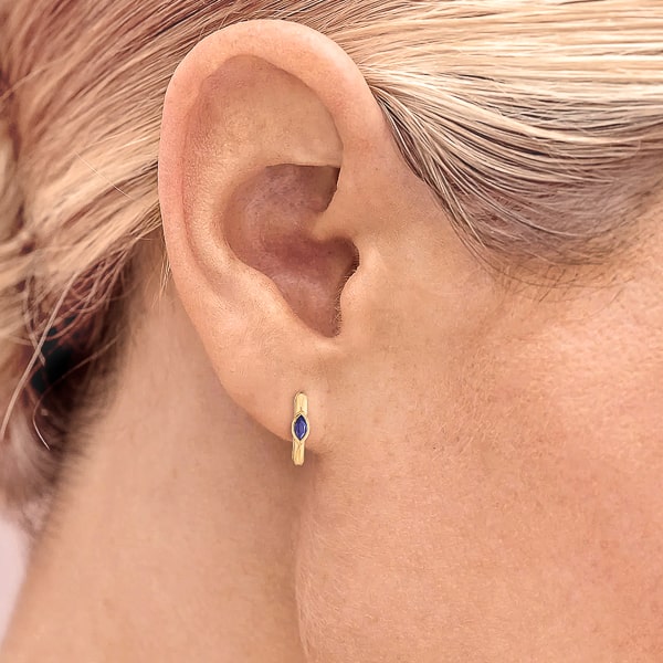 Woman wearing gold blue mini marquise hoop earrings