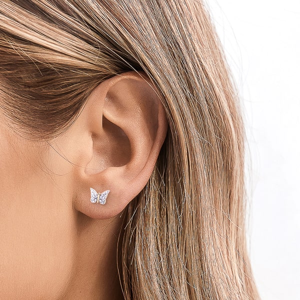 Woman wearing gold butterfly stud earrings