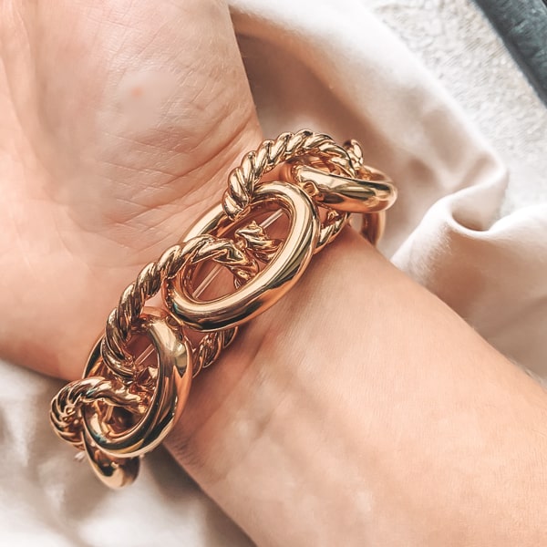 Gold chunky designer bracelet on a woman's wrist