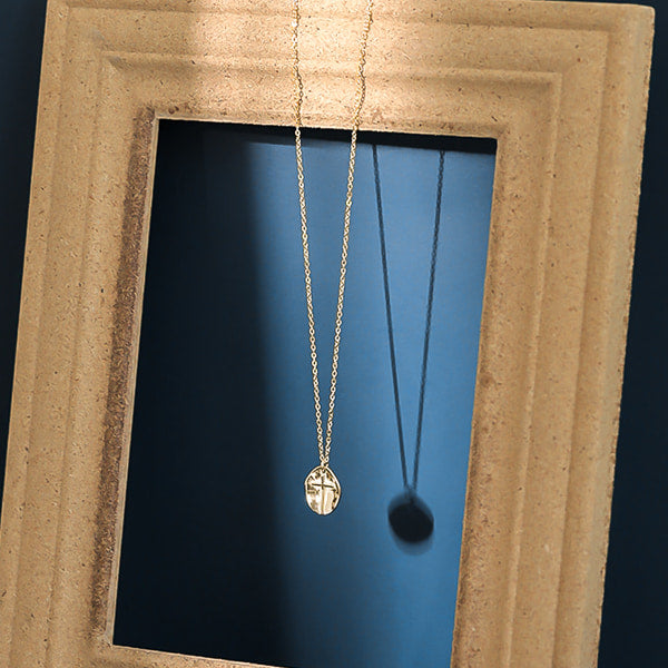 Gold coin cross pendant necklace display