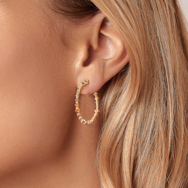 Woman wearing gold colorful crystal hoop earrings
