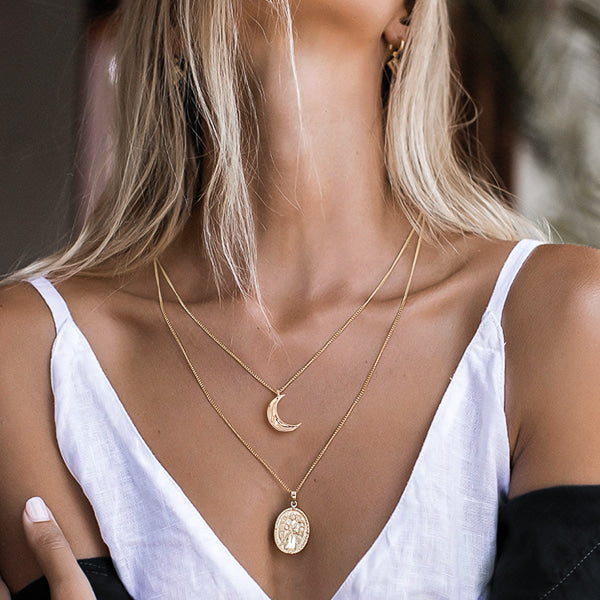 Woman wearing a gold crescent moon necklace