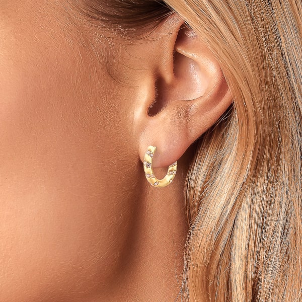 Woman wearing gold crystal spiral hoop earrings