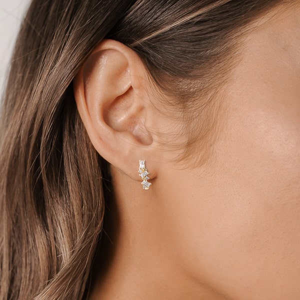 Woman wearing gold crystal U hoop earrings