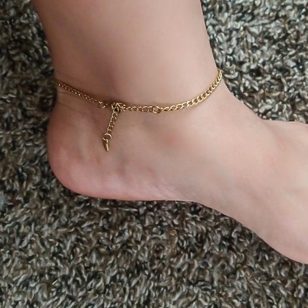 Gold curb chain ankle bracelet on an ankle