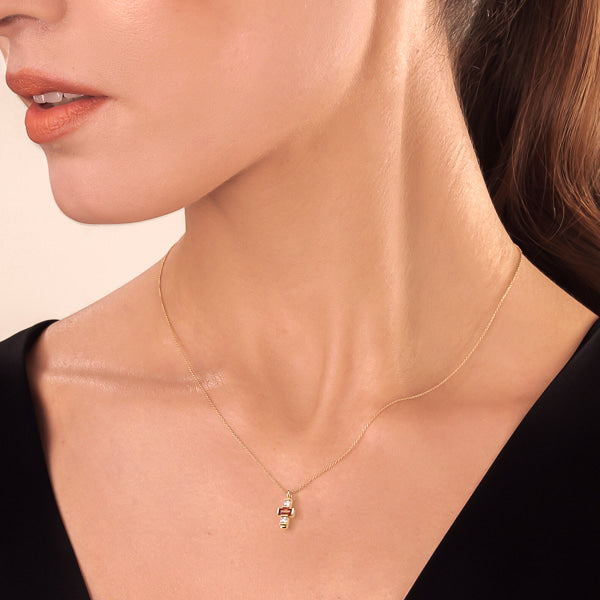 Woman wearing a dainty white & cognac crystal cross on a gold necklace
