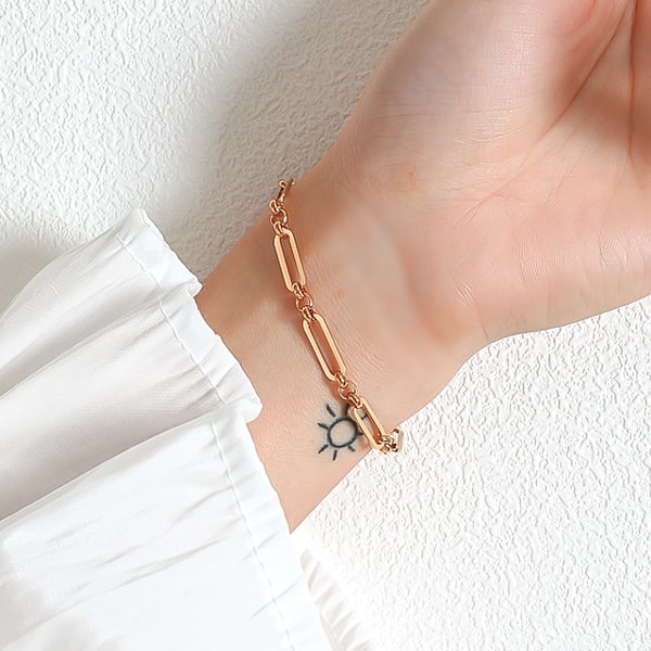 Gold designer oval link chain bracelet on a woman's wrist