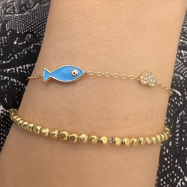 Gold vermeil fish bracelet on woman's wrist