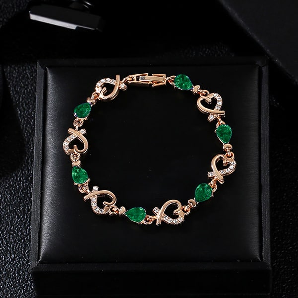 Gold heart chain bracelet with green crystals details
