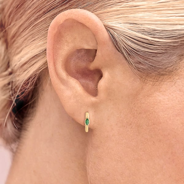Woman wearing gold green mini marquise hoop earrings