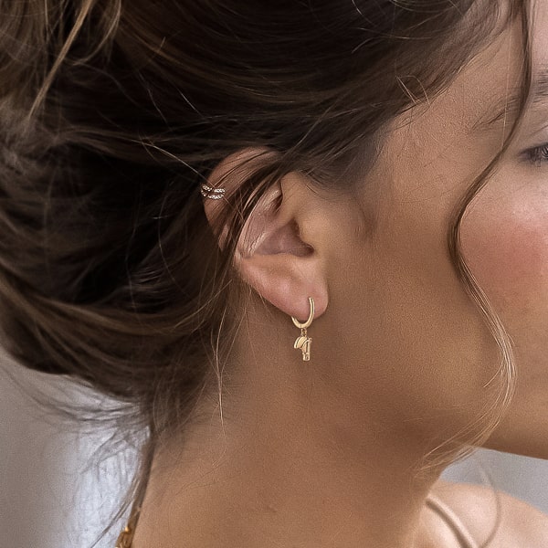 Woman wearing gold horse hoop earrings