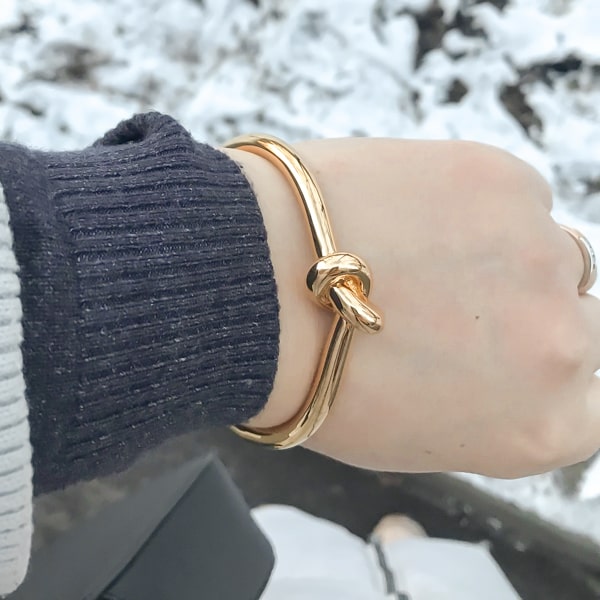 Gold knot cuff bracelet on a woman's wrist
