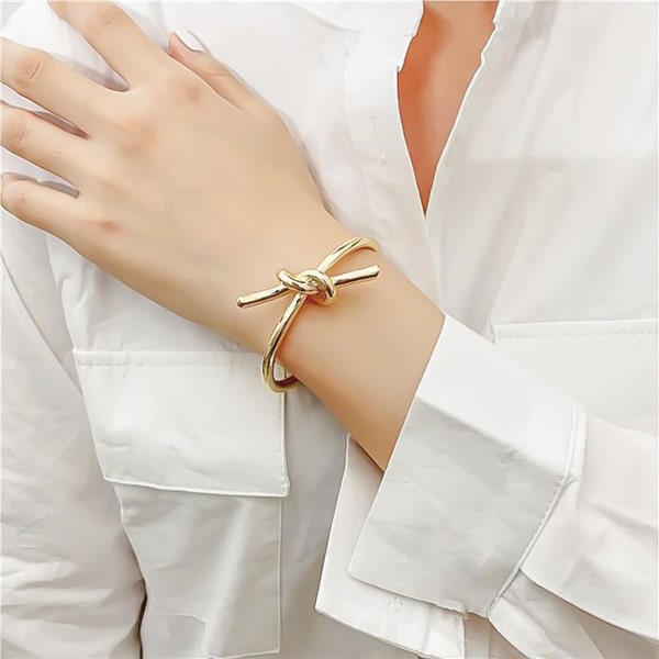 Gold lace knot cuff bracelet displayed on woman's wrist