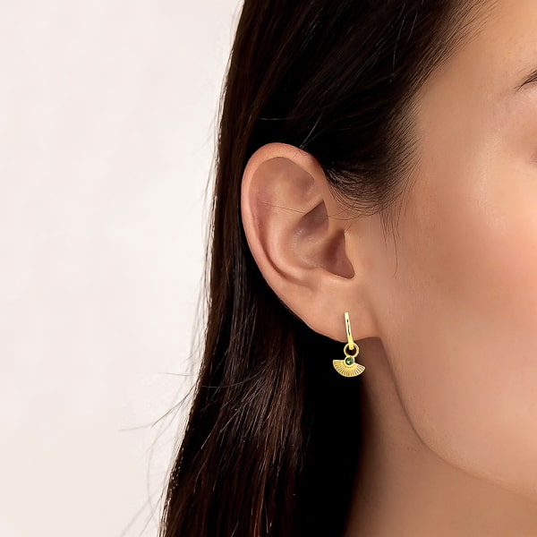 Woman wearing gold mini scallop shell drop hoop earrings